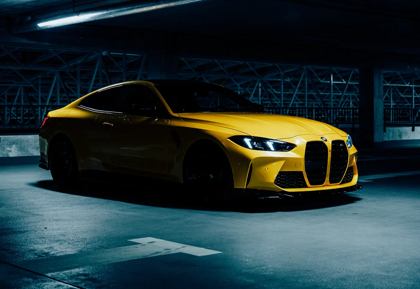 Żółte BMW M4 Competition z floty Ferrum Cars w garażu podziemnym